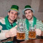 smiling men raising beer mug in pub