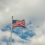an american flag flying in the wind on a cloudy day