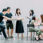 two men and four women meeting in office