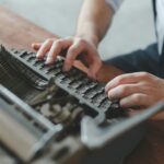 a man typing on an old fashioned typewriter