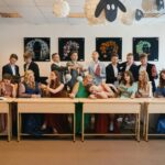 a group of people sitting at a long table