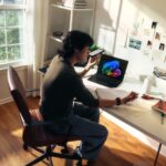 Person working at a desk with a laptop and books.